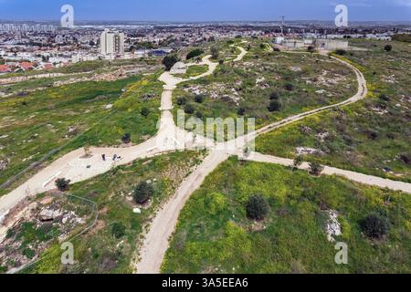 Photo surplombant la ville de Rosh HaAyin. Printemps en Israël. De l'herbe verte fraîche pousse sur les collines du parc Yarkon. Prise de vue à vol d'oiseau Banque D'Images