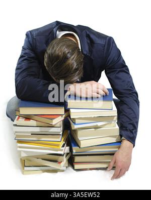 Jeune étudiant de dormir sur des piles de livres, isolated on white Banque D'Images