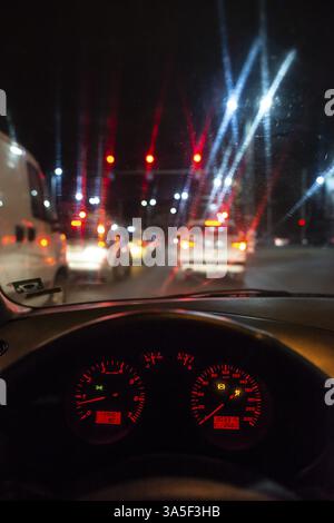 Tableau de bord de voiture et fenêtre la nuit. Feux de circulation Banque D'Images