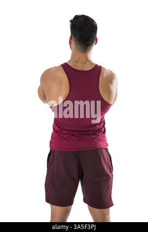 Dos d'homme musclé dans le haut sans manches rouge et short, regardant un espace vide devant lui, isolé sur blanc en studio Banque D'Images