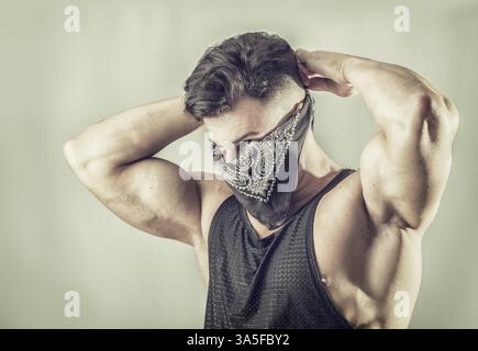 Beau jeune homme musclé avec masque sur le visage comme un voleur ou un bandit Banque D'Images