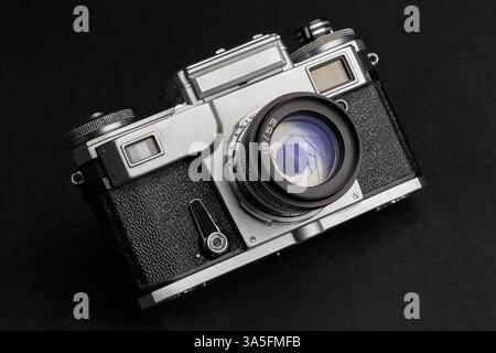 Vieil appareil photo télémétrique avec objectif sur fond sombre gros plan Banque D'Images