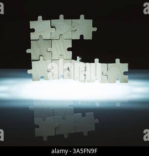 Puzzle en bois et fond de rétro-éclairage. Pièces empilées verticalement Banque D'Images