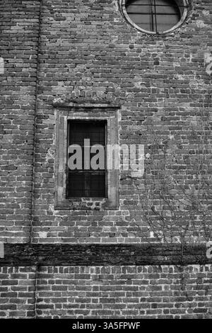 Vieille fenêtre sur un mur de briques – architecture historique en noir et blanc Banque D'Images