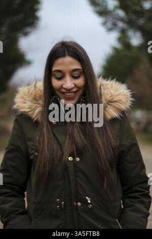 Jeune et belle femme heureuse souriant lors d'une excursion et promenade dans une forêt Banque D'Images