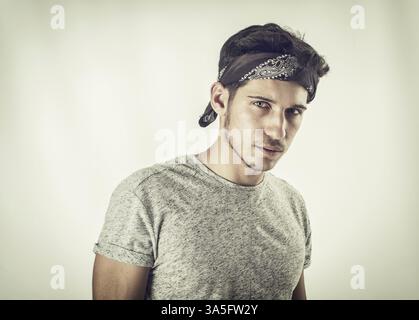 Beau jeune homme aux yeux verts avec bandana noir, en studio Banque D'Images