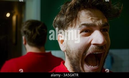 Homme criant devant un miroir, exprimant frustration, colère ou détresse émotionnelle, dépeignant des thèmes de dépression, de troubles intérieurs et personnels Banque D'Images