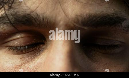 Gros plan des yeux intenses d'un homme avec des sourcils sillonnés, véhiculant la concentration ou la détermination Banque D'Images