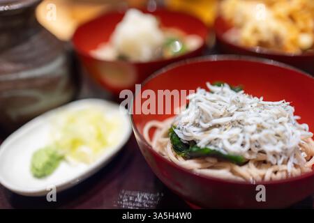 Plat japonais de nouilles soba garni de poisson blanc et de légumes verts, faisant partie d'un repas traditionnel de teishoku Banque D'Images