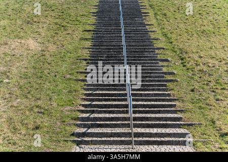 Un long ensemble d'escaliers avec une balustrade en métal. Les escaliers sont en béton et recouverts d'herbe Banque D'Images