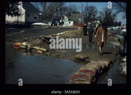 Cette photographie montre la résidence Fitch située au 416 North Eighth Street, dans le quartier de Peter pendant l'inondation de 1965. Des sacs de sable sont placés autour de la maison pour détourner l'eau de Sunrise Drive vers le champ de loisirs et la rivière Minnesota. Banque D'Images