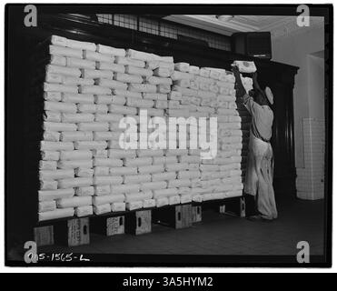 On voit des travailleurs empiler des sacs de farine dans le magasin soigné et ordonné de la filiale à U.S. Coal and Coke Company’s Gay Mines dans le comté de McDowell, en Virginie-occidentale. Ce magasin répondait aux besoins des familles minières. Banque D'Images