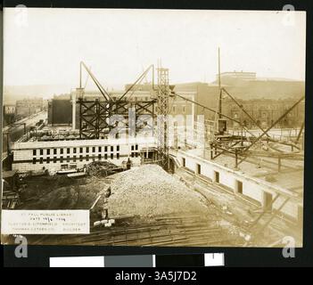 Cette photographie capture la construction du deuxième étage de la Bibliothèque centrale à Saint Paul, Minnesota, montrant des échafaudages, des matériaux de construction et des travailleurs sur place. Il met en évidence l'utilisation d'un « moteur à âne » à vapeur pour le levage de matériaux, avec des ouvriers installant des fenêtres et construisant des murs. Banque D'Images