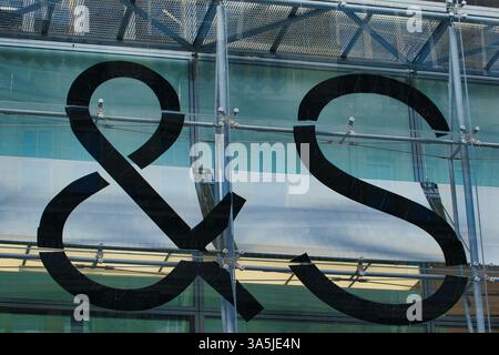 Esperluette noire et lettre S sur façade en verre avec structure de support en métal. Prise de vue extérieure, la lumière est brillante à Manchester, Royaume-Uni. Banque D'Images