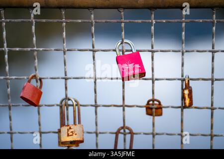 Vue de cadenas vieux et nouveaux colorés sur la clôture en fer du pont Banque D'Images