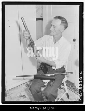 Harry Fain, un chargeur de charbon aux mines Wheelwright de la Inland Steel Company dans le comté de Floyd, au Kentucky, nettoie son fusil de chasse, un outil essentiel pour son passe-temps de chasse aux écureuils. Banque D'Images