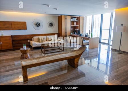 Intérieur moderne du salon de l'hôtel, mobilier en bois, carrelage et grandes fenêtres avec vue sur la mer des Caraïbes. Mexique. Cancun. Banque D'Images