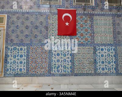 Istanbul - 22 septembre 2024 - drapeau turc accroché à un mur décoré de tuiles iznik colorées, mettant en valeur l'art et l'architecture ottomans. , mosquée eyup c Banque D'Images