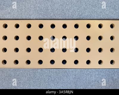 Série de panneaux rembourrés gris avec plaque métallique dorée horizontale. Cela fonctionne comme mur rembourré de coussin à l'isolation phonique, ou tissu mural acoustique Banque D'Images