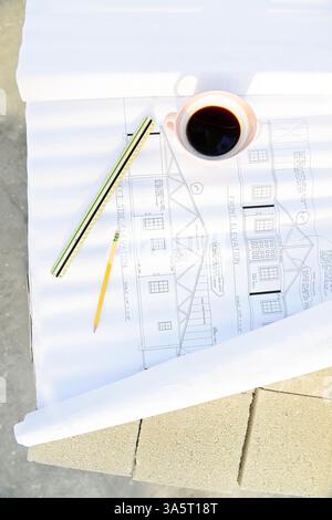 Plan avec café, règle et crayon sur un chantier de construction Banque D'Images