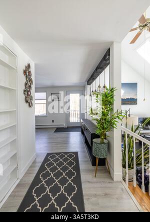 Couloir avec tapis dans la maison moderne légère mène à la porte d'entrée. Banque D'Images