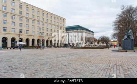 Krakowskie Przedmiescie à Varsovie, Pologne par temps nuageux. Route touristique populaire avec des hôtels de luxe et Stefan Wyszynski Monument. Banque D'Images