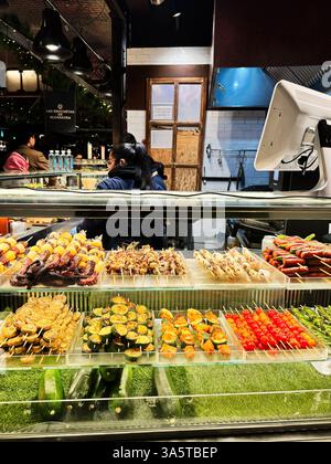 Madrid, Espagne - 28 décembre 2023 : brochettes de légumes et de viandes grillés colorés exposées dans un marché mexicain animé à Madrid, Espagne Banque D'Images