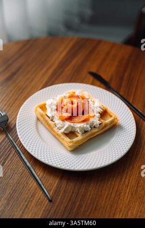 Gaufres belges au saumon sur fond de bois, petit déjeuner, poisson rouge. Banque D'Images