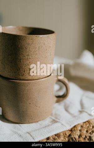Deux tasses avec une couleur marron et une texture rugueuse. Ils sont placés sur un chiffon blanc. Les tasses ne sont remplies de rien Banque D'Images