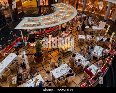 Photo à angle élevé d'un salon de thé dans un centre commercial à Singapour, avec des tables et des personnes assises avec des serveurs se promenant. Banque D'Images