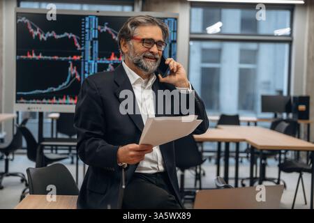 Appel téléphonique. L'homme senior est dans le bureau moderne. Banque D'Images