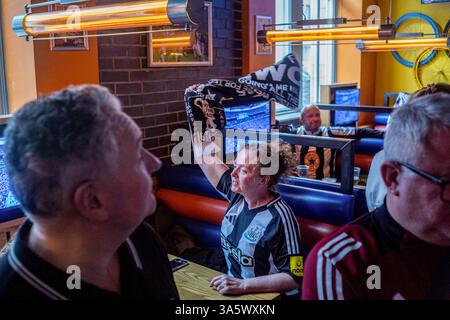 Dans un bar sportif Marylebone, une supporteuse agite son foulard en prévision du coup d'envoi de la finale de la Coupe de la Ligue de Carabao. Dans l'après-midi du 16 mars, des dizaines de milliers de fans de Newcastle United descendent. Wembley Way au stade de Wembley pour la finale de la Coupe de la Ligue de Carabao contre Liverpool. Sans une victoire de trophée domestique en 70 ans, la « Toon Army » marche sur la célèbre route avec excitation, espoir et pensées de victoire. Plus tard dans la journée, les fans de Newcastle sans billet regardent le match dans un événement du Sports Bar organisé par le supporter's Trust dirigé par les fans du club. Après une victoire de 1-2 sur Liverpool, t Banque D'Images