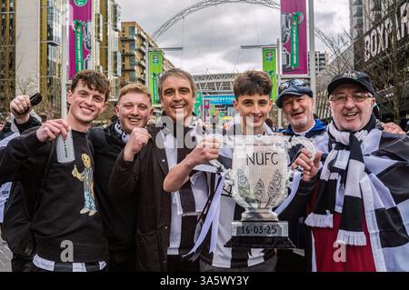 Un groupe de fans de Newcastle United pose avec une maquette découpée en carton de la Coupe de la Ligue de Carabao. Dans l'après-midi du 16 mars, des dizaines de milliers de fans de Newcastle United descendent. Wembley Way au stade de Wembley pour la finale de la Coupe de la Ligue de Carabao contre Liverpool. Sans une victoire de trophée domestique en 70 ans, la « Toon Army » marche sur la célèbre route avec excitation, espoir et pensées de victoire. Plus tard dans la journée, les fans de Newcastle sans billet regardent le match dans un événement du Sports Bar organisé par le supporter's Trust dirigé par les fans du club. Après une victoire de 1-2 sur Liverpool, les fans de Newcastle l Banque D'Images