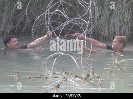 13 novembre 2004 ; Lutafiyah, Iraq ; le Cpl WYATT SCHERTENLEIB et le Cpl ADAM SMITH de la 24e unité expéditionnaire des Marines aident à sécuriser une barrière en fil de concertina dans un canal, en amont d'un pont récemment détruit à Lutafiyah, Iraq, le 13 novembre. Ils ont installé le câble pour empêcher d'éventuels engins explosifs improvisés flottants d'entraver les efforts de reconstruction du pont de la MEU. Le pont a été gravement endommagé lors d'attaques répétées de militants anti-irakiens. Schertenleib, 21 ans, est une République, Wash., natif et Smith, 21, est un natif de Ripley, W.Va. Les deux sont des ingénieurs de combat avec le détachement d'ingénieur, Banque D'Images