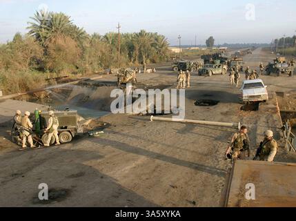 13 novembre 2004 ; Lutafiyah, Irak ; Marines et marins de la 24e unité expéditionnaire des Marines inspectent les restes d'un pont à Lutafiyah, Irak, 13 novembre, avant de commencer les efforts de reconstruction. Le pont a été gravement endommagé lors d'attaques répétées de militants anti-irakiens. La 24e MEU mène actuellement des opérations de sécurité et de stabilité dans la province de Babil, au nord du pays. Banque D'Images