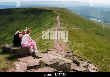 JEUNE COUPLE, FAN DE PEN Y, HABITANTS, TOURISTES, MARCHEURS, ARCHIVE, 2002 : les gens locaux se mêlent aux touristes au sommet de la montagne Pen y Fan dans les Brecon Beacons, pays de Galles, Royaume-Uni le 2002 septembre. Photo : Rob Watkins. INFO : Pen y Fan, le plus haut sommet du sud du pays de Galles (et donc du sud du Royaume-Uni), se situe à 886 mètres dans le parc national de Brecon Beacons. Destination de randonnée populaire, elle offre des vues à couper le souffle, des sentiers pittoresques et une expérience enrichissante au sommet, attirant les marcheurs, les amoureux de la nature et les photographes toute l'année. Banque D'Images
