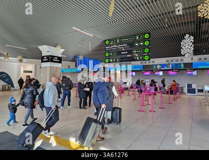 IASI, ROUMANIE - 5 JANVIER 2025 L'aéroport moderne de Iasi vue intérieure du nouveau terminal T4 avec les passagers tirant les bagages, les bornes d'enregistrement de tête et b Banque D'Images
