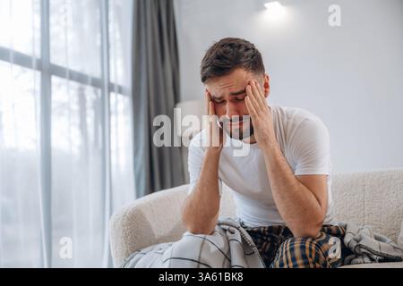 Terrible mal de tête. L'homme malade se sent mal à la maison. Banque D'Images