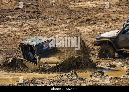 Véhicule hors route endommagé, moteur noyé, véhicule coincé dans un fossé avec de l'eau et de la boue, essayez de tirer la voiture hors du marais Banque D'Images