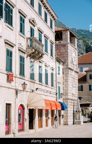 Monténégro, Kotor - 07 juillet 2024 : ancien bâtiment en pierre avec des revêtements colorés près de l'ancienne tour de l'horloge. Kotor, Monténégro Banque D'Images