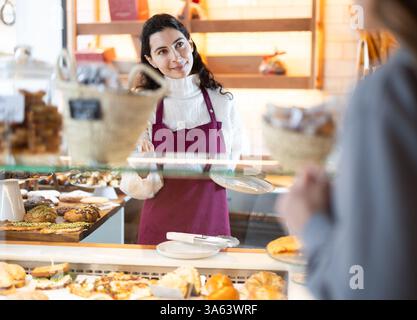 Fille vendeuse travaille dans la boutique de boulangerie cafétéria Banque D'Images