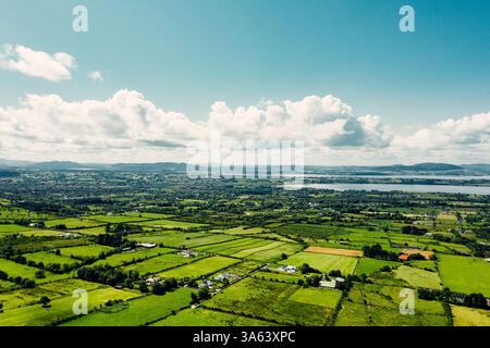 Endless Emerald : vue aérienne au coucher du soleil sur la campagne irlandaise enchanteresse avec des pâturages luxuriants et des terres agricoles Banque D'Images