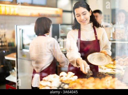 Fille vendeuse travaille dans la boutique de boulangerie cafétéria Banque D'Images