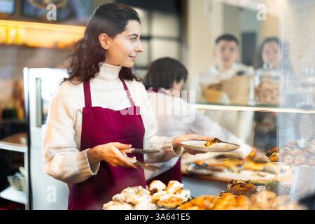Fille vendeuse travaille dans la boutique de boulangerie cafétéria Banque D'Images