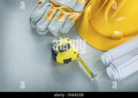 Ensemble de gants protecteurs de casque de construction de plans ruban de mesure sur fond de béton Banque D'Images