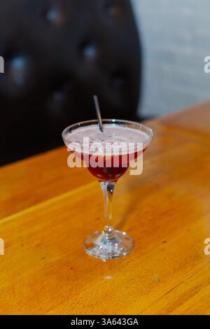 Cocktail rouge avec verres à cocktail en mousse blanche avec un tube de boisson alcoolisée Banque D'Images