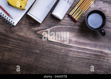 Photolivre à carreaux crayons bleus mesure ruban mètre en bois et tasse de café sur planche en pin Banque D'Images