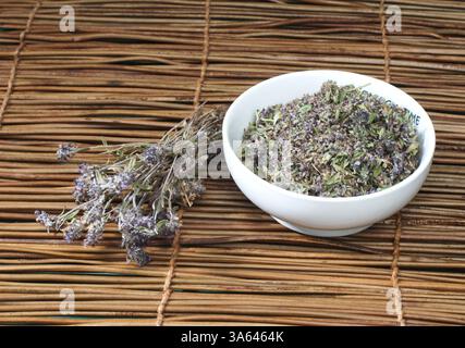 Thym séché dans un bol sur un socle en bois Banque D'Images