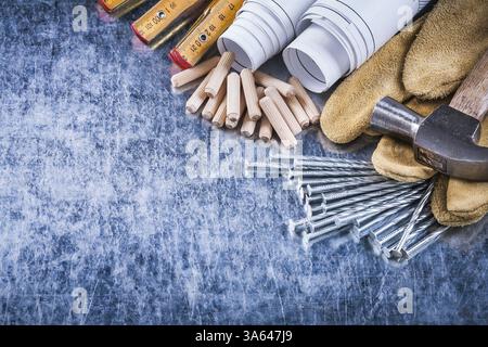 Blueprints marteau gants de sécurité en bois construction de mètres clous et tas de chevilles sur le concept d'entretien de surface métallique rayée Banque D'Images