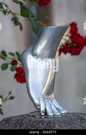 Pied de femme sur la pointe des pieds, sculpture argentée, métallique brillant, roses rouges dans le fond, Steinbach, Michelstadt, Odenwald, Hesse, Allemagne, E Banque D'Images